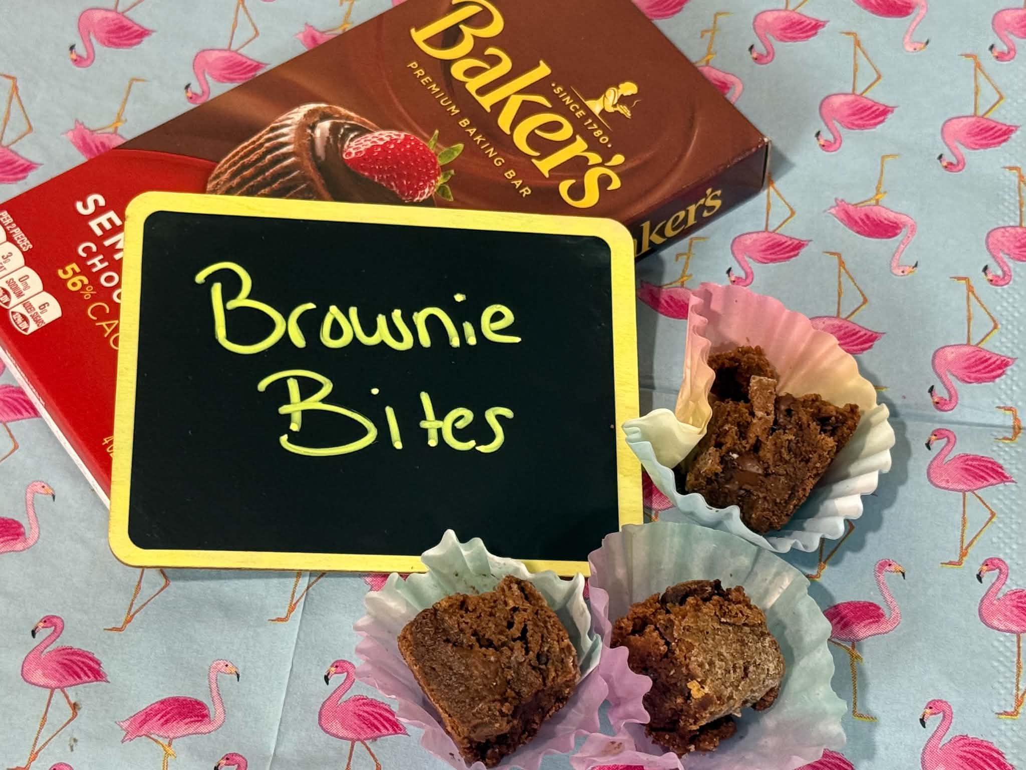 Fudgy brownie bites in pastel cupcake liners with a Baker's chocolate bar
