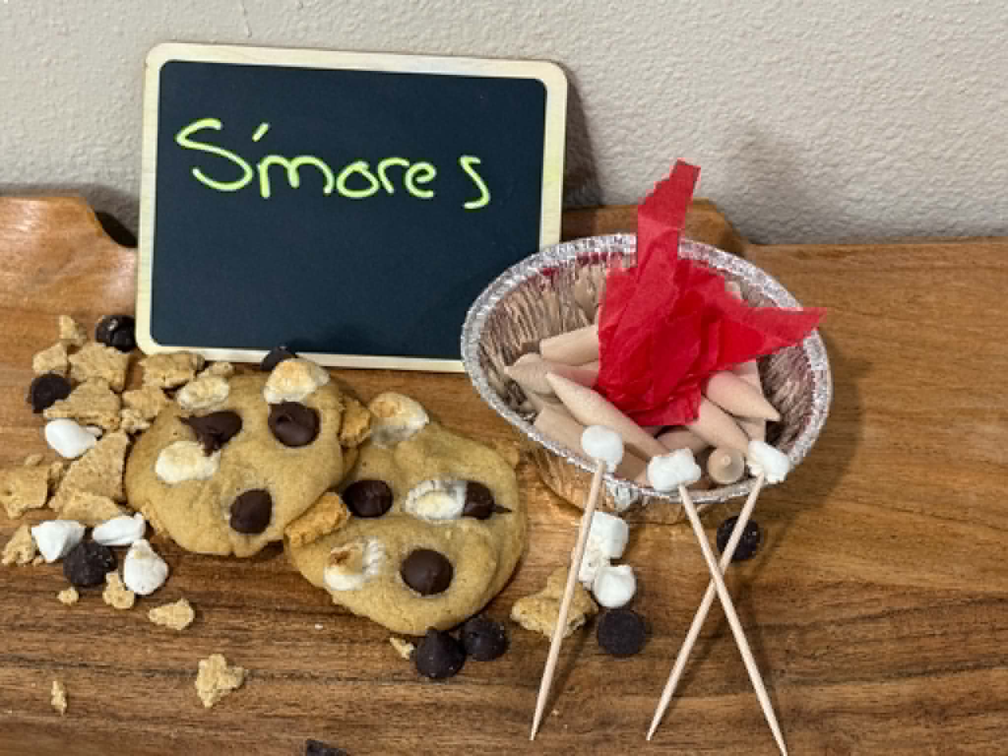 S'mores cookies styled with a mini campfire of marshmallow skewers